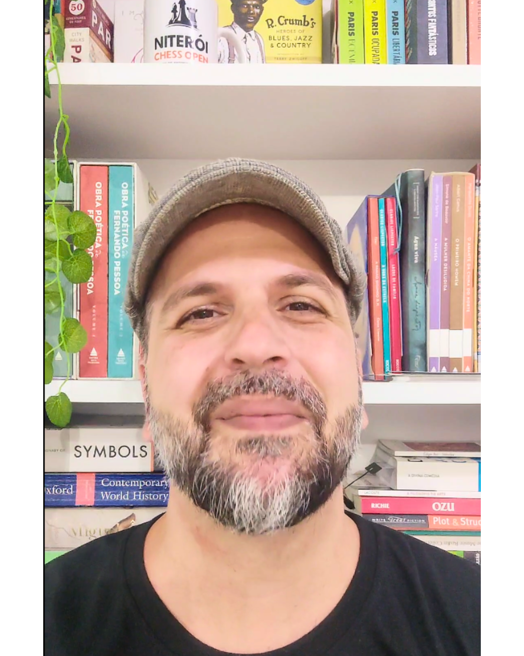 Sandro Massarani diante de uma estante de livros